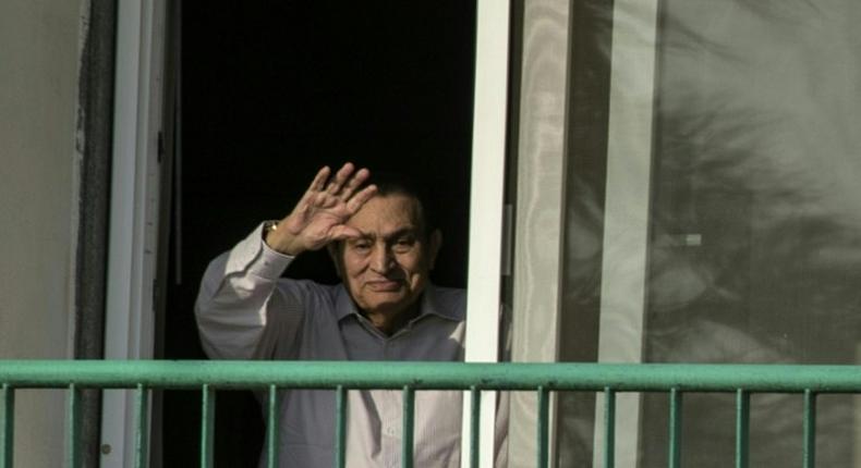 Former Egyptian president Hosni Mubarak waves to supporters from his room at the Maadi military hospital in Cairo on October 6, 2016