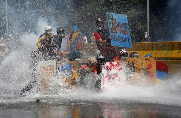 Opposition supporters clash with riot security forces while rallying against President Nicolas Madur