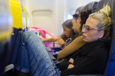 Tired lady napping on airplane.