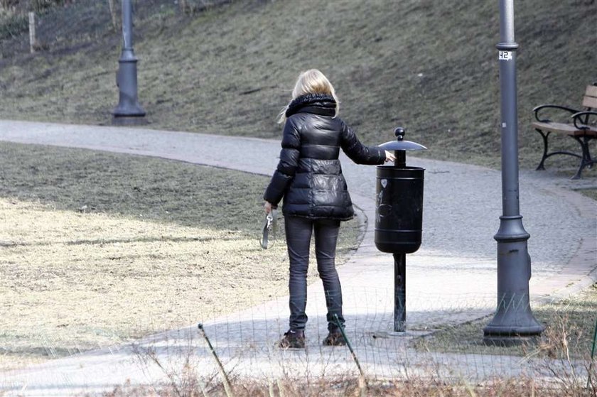 Torbicka sprząta po psie. Foto