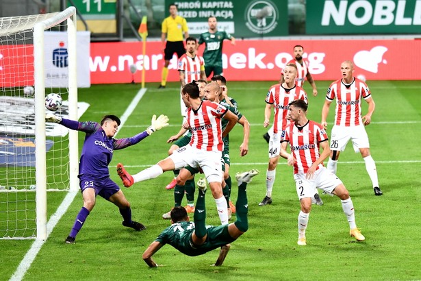 Piłkarz Śląska Wrocław Wojciech Golla (C-przód) pokonuje bramkarza Karola Niemczyckiego (L) z Cracovii podczas meczu Ekstraklasy