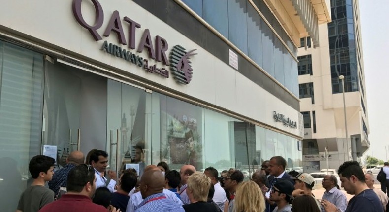 People gathered outside a branch of Qatar Airways in the Emirati capital of Abu Dhabi on Tuesday as travellers sought alternative travel plans because of bans on the airline