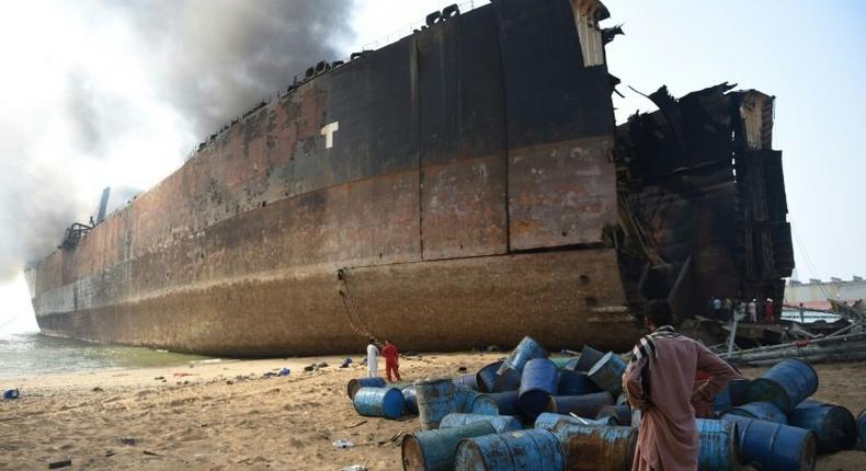 A Pakistani man looks at the wreckage of a burning ship a day after a gas cylinder explosion at the Gadani shipbreaking yard