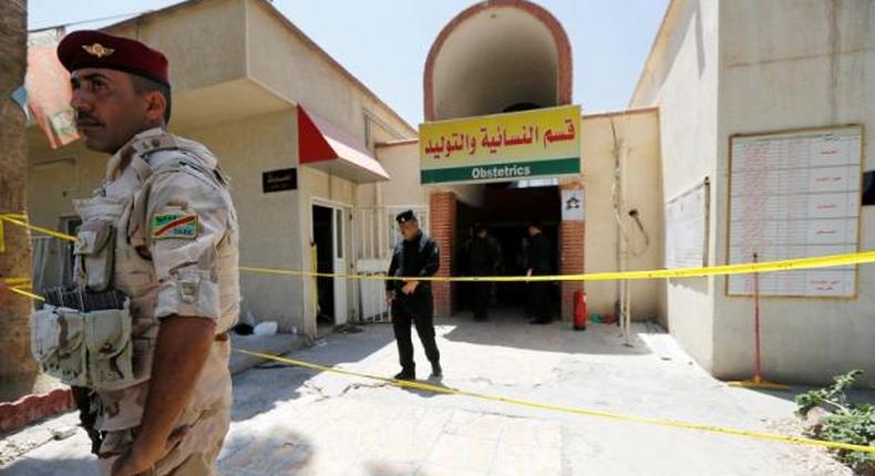 Iraqi security forces stand guard in front of a maternity ward after a fire broke out at Yarmouk hospital in Baghdad, Iraq, August 10, 2016.