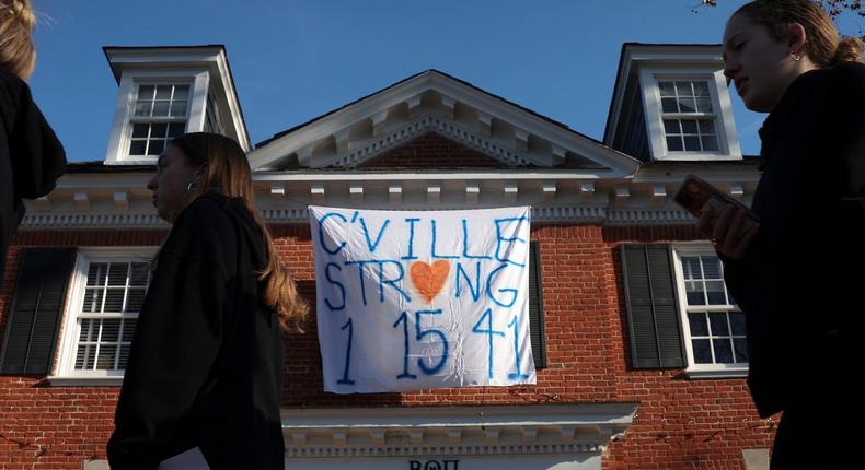 Students walk past a fraternity house with a banner memorializing three University of Virginia football players killed during a shooting at the school.Win McNamee/Getty Images