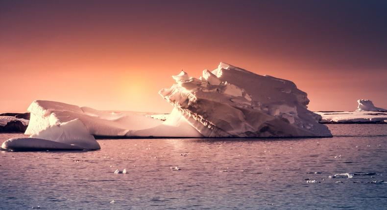 A photo illustration of an Antarctic iceberg at sunset.