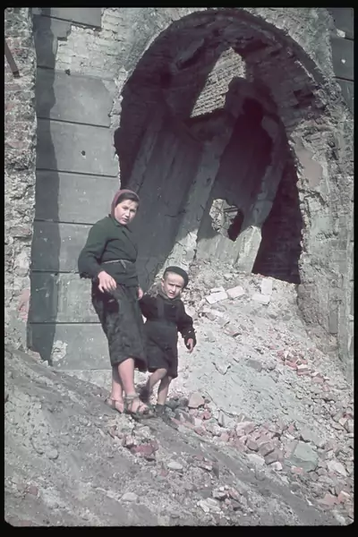 Zdjęcie z Warszawy. Kobieta i dziecko schodzą po zgliszczach budynków. Późny 1939 r.  / (Photo by Hugo Jaeger/Timepix/The LIFE Picture Collection via Getty Images)