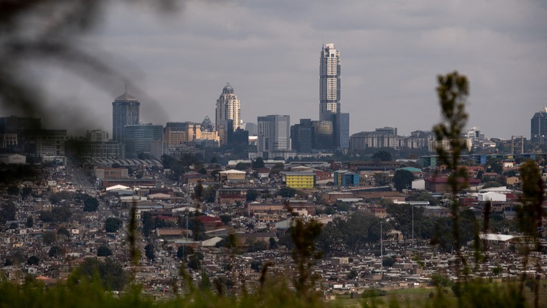 A general view of the Alexandra township with the Sandton cityscape in the background taken from Linbro Park in Johannesburg on May 4, 2025. [Photo by EMMANUEL CROSET/AFP via Getty Images]