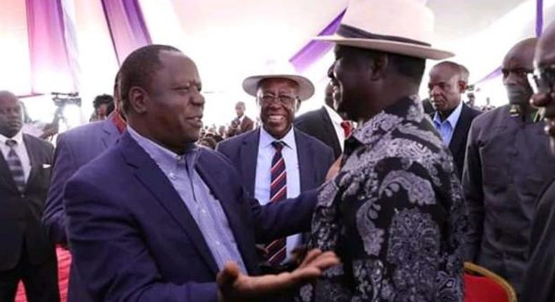 Raila Odinga with Fred Matiangi at the burial of Hezron Manduku