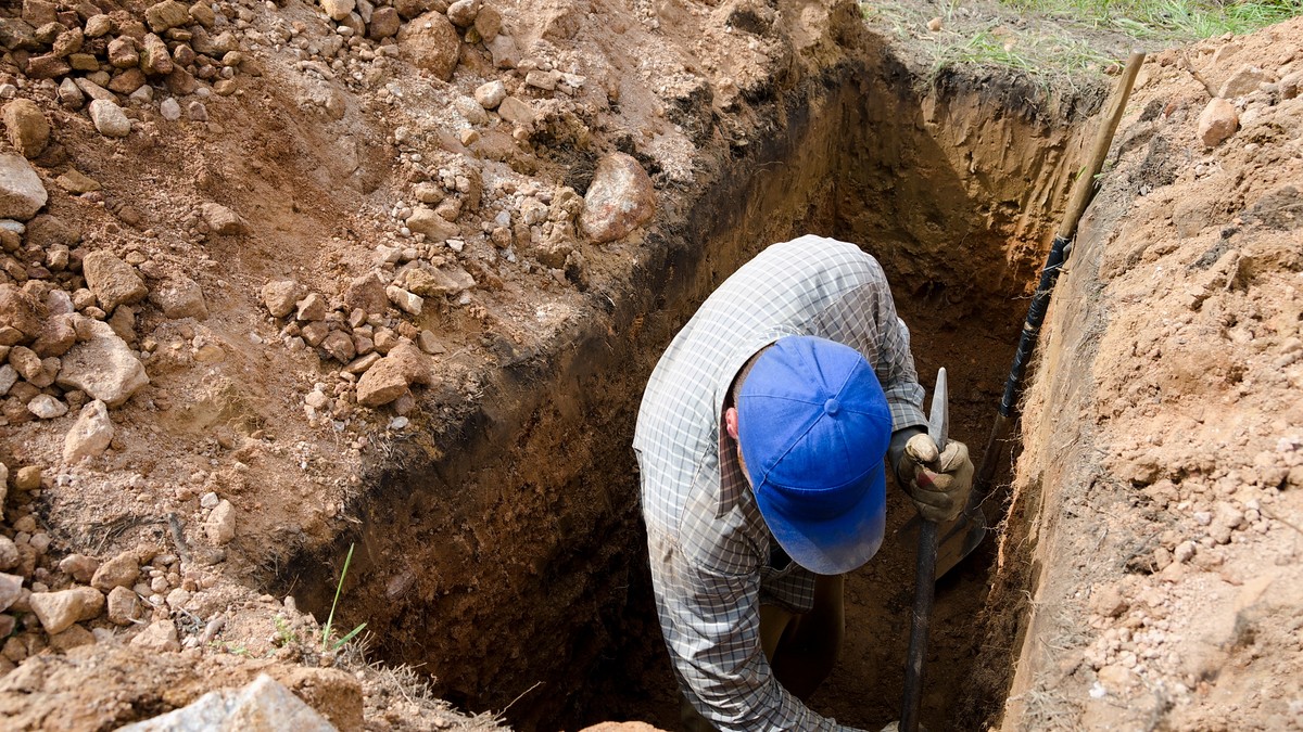 Muškarac kopa grob