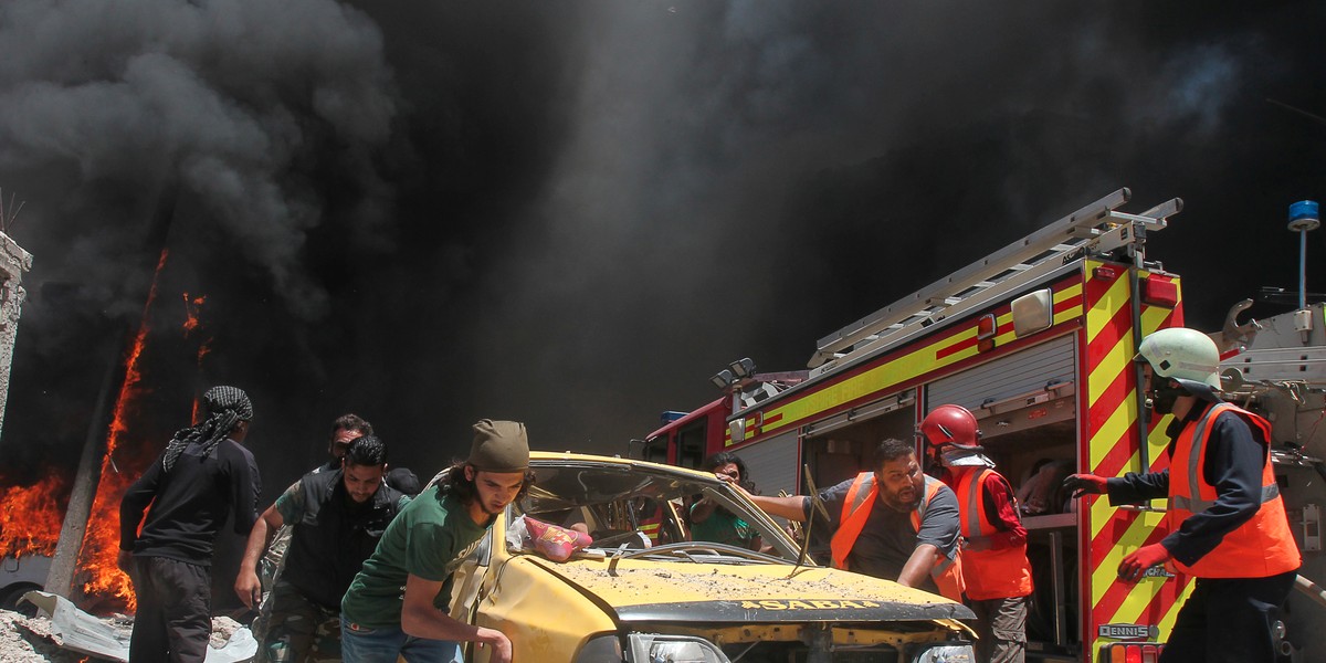 Civil-defense members and rescuers at a site hit by airstrikes in the city Idlib in Syria.