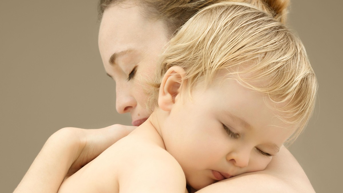 Mother holding sleeping baby boy (9-12 months), close-up