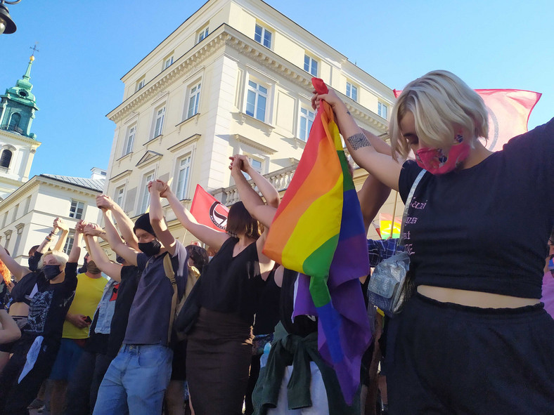 Uczestnicy manifestacji tańczą, trzymając się za ręce