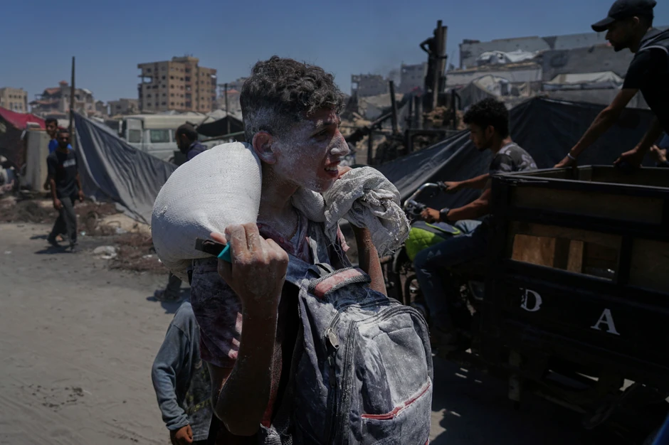 Palestinci nose pomoć iz humanitarnog konvoja koji je stigao u Gaza Siti sa severa enklave 22. jula