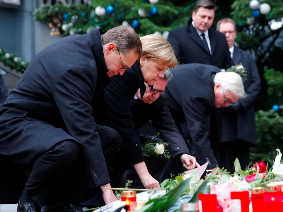 Angela Merkel lays flowers at the Christmas market in Berlin.