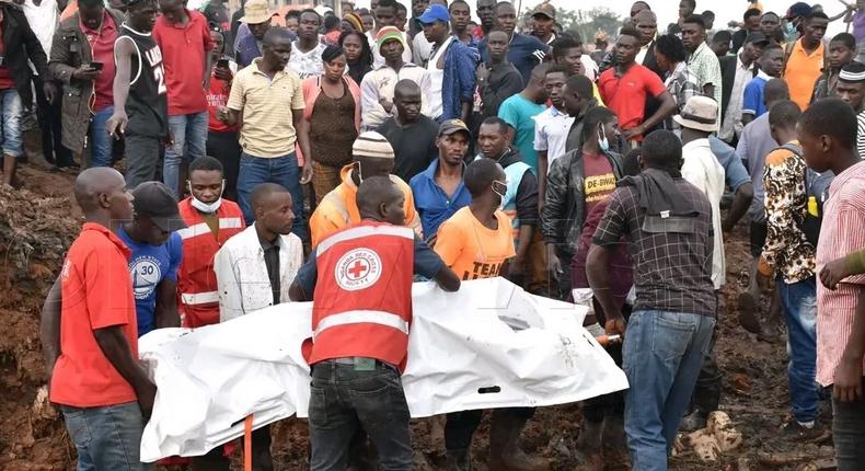 Red Cross first responders retrieve a body from the collapsed landfill