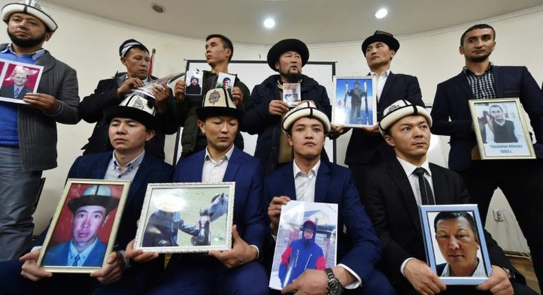 Kyrgyz family members hold portraits of their relatives who they fear are being held in notorious re-education camps in China's Xinjiang region