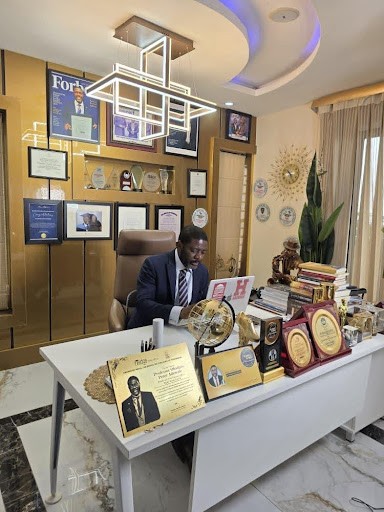 Professor Obadare at work in his home office with hundreds of awards around him.