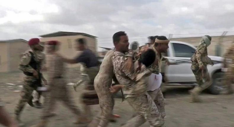 An image grab taken from a video obtained by AFPTV shows a wounded Yemeni soldier being carried by comrades after a drone strike on Yemen's Al-Anad air base in the government-held southern province of Lahj on January 10, 2019 that killed six soldiers