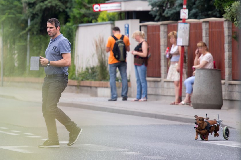 Paweł Deląg z psem na wózku inwalidzkim na spacerze