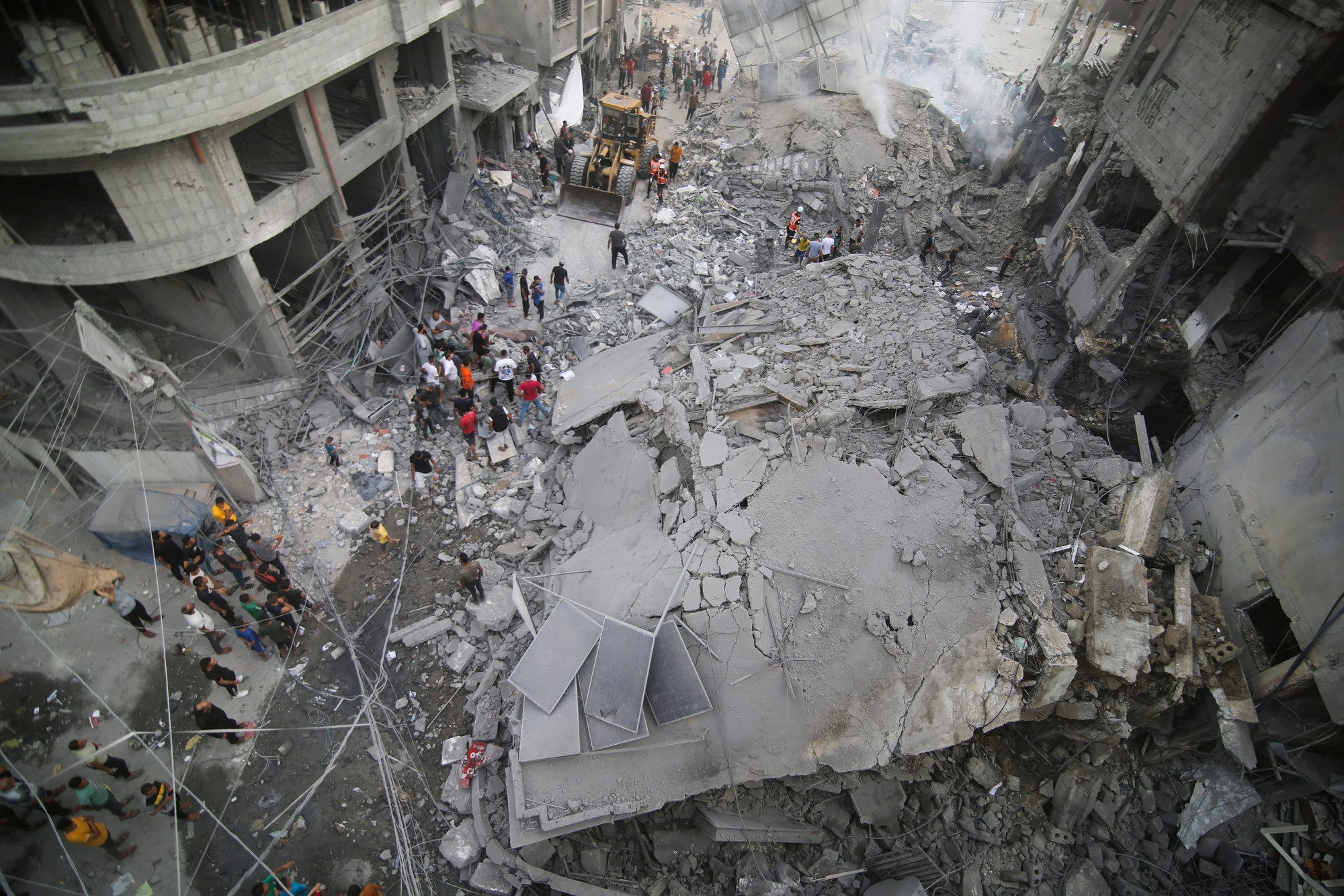 Palestínčania kontrolujú vyskytujúce sa poškodenie zničenej budovy, v dôsledku po tom, čo sa udiali izraelské nálety v Khan Younis, Pásmo Gazy, dňa 10. októbra 2023.