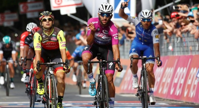 Colombian cyclist Fernando Gaviria (C) crosses the finish line to win the 12th stage of the 100th Giro d'Italia race from Forl“i to Reggio Emilia on May 18, 2017 in Reggio Emilia