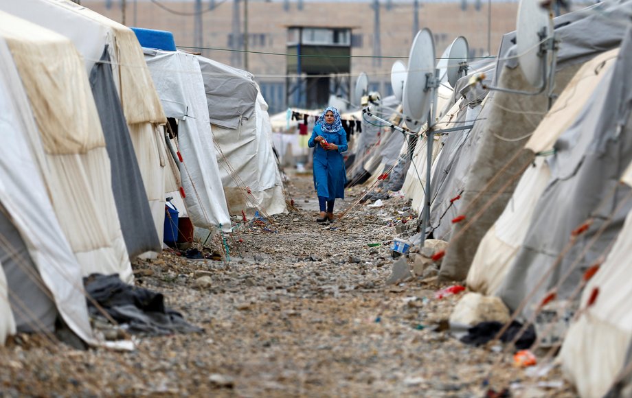 A Syrian refugee woman walks between tents in Nizip refugee camp, near the Turkish-Syrian border in Gaziantep province, Turkey, November 30, 2016.