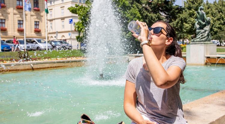 Egy nő iszik egy szökőkútnál Szegeden júliusban. Aznap vörös kódos riasztás volt érvényben, mert a napi átlagos középhőmérséklet meghaladta a 27 Celsius-fokot