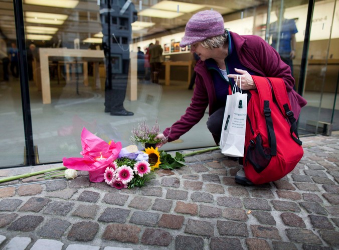 Tamara Holden z Kalifornii składa kwiaty pod sklepem Apple'a we Frankfurcie nad Menem