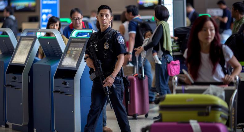 A US Customs and Border Protection officer watches travelers at Los Angeles International Airport on July 2, 2016.
