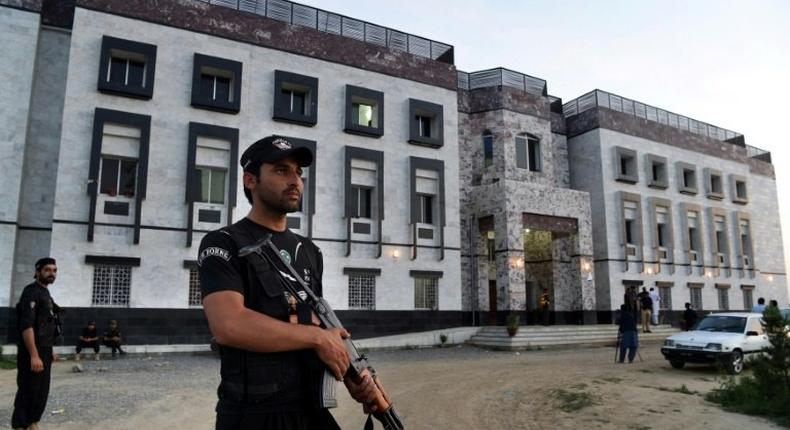 Pakistani policemen stand guard outside the hostel at Abdul Wali Khan university where students beat to death a classmate in Mardan on April 13, 2017