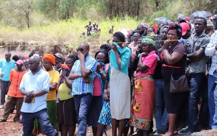 A crowd at the scene where Catholic priest Michael Kyengo's body was recovered