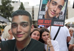 Okupljeni na dočeku u Tel Avivu nose transparente sa likom Idana Aleksandera | Foto: REUTERS/Ronen Zvulun