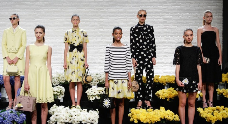 Kate Spade models show off the retailer's collections. The classic look and subtle logos are helping the retailer's popularity with young women, according to Goldman Sachs.