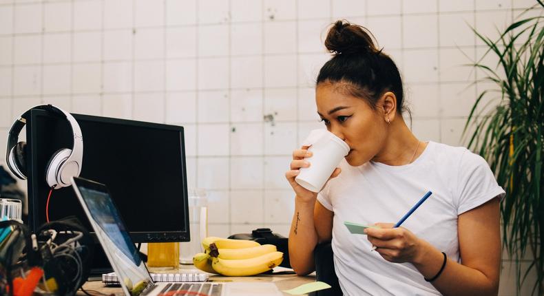 woman working drinking coffee laptop