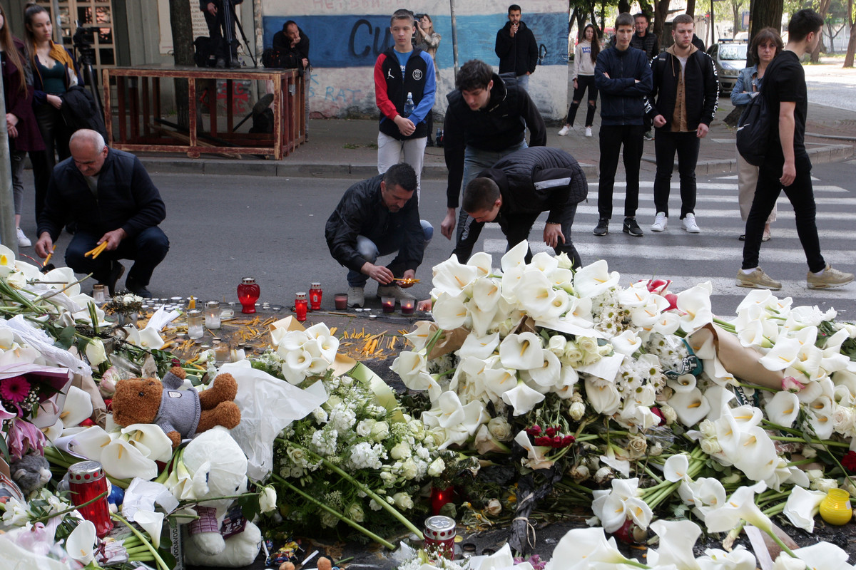 Građani ispred Osnovne škole "Vladislav Ribnikar" pale sveće i ostavljaju cveće kako bi odali počast stradalim učenicima i zaposlenom radniku
