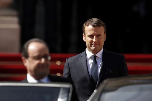 Former French President Francois Hollande leaves as President Emmanuel Macron watches after the hand