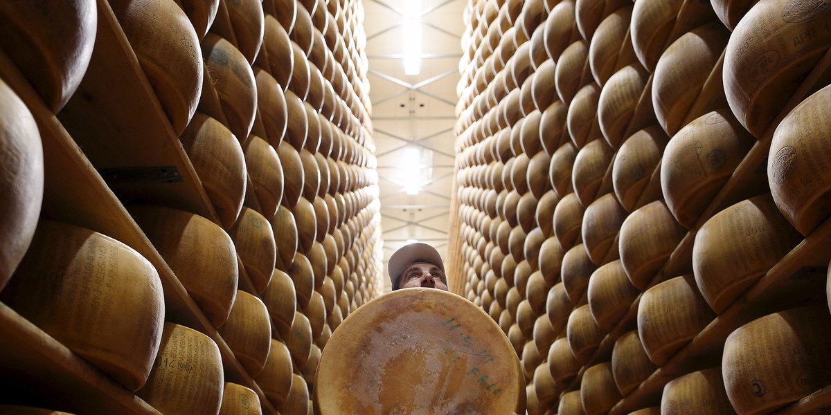 Worker carries fresh Parmesan wheel off storehouse shelf a 4 Madonne Caseificio dell'Emilia dairy cooperative in Modena, Italy, February 16, 2016.