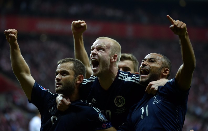 Polak Arkadiusz Milik (L) fetuje z Arturem Jędrzejczykiem (P) strzelenie bramki drużynie Szkocji na 2-2 podczas meczu eliminacyjnego piłkarskich mistrzostw Europy