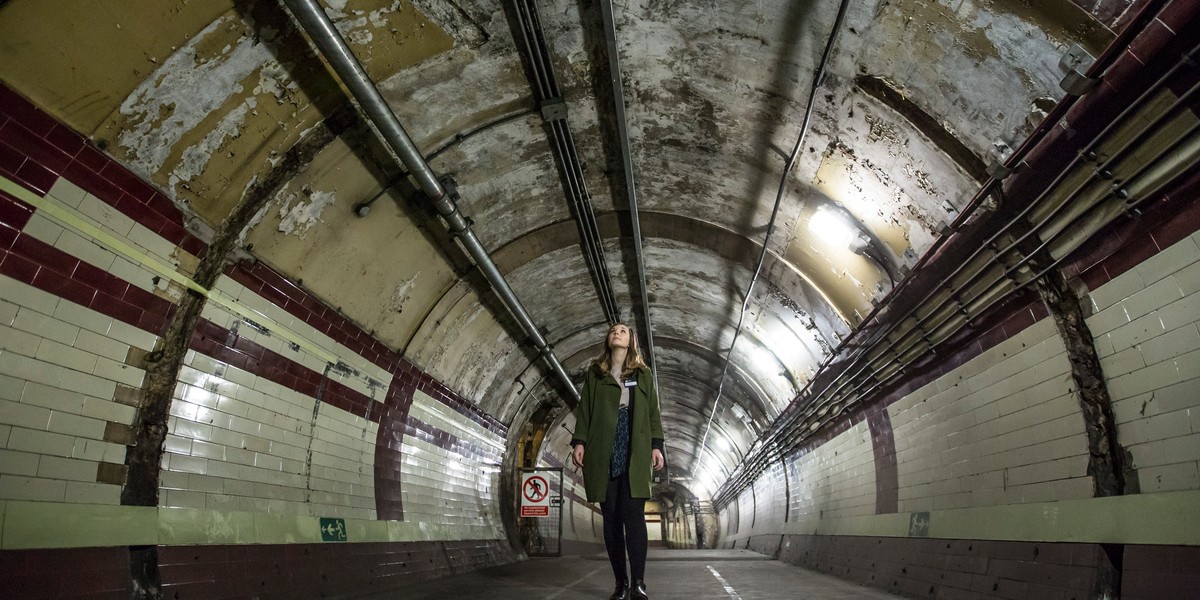 Pracowniczka Londyńskiego Muzeum Transportu idzie podziemnym tunelem.