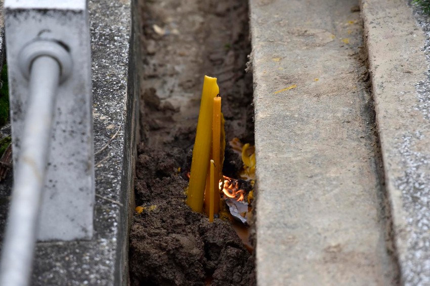 Upaljene sveće nakon što je pop ponovo osveštao grob
