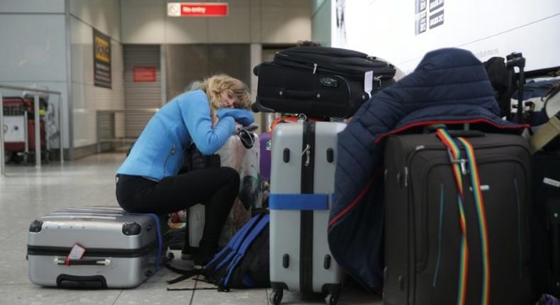 A traveller sleeps next to luggage at London's Heathrow Airport after British Airways cancelled all flights from the major travel hub on May 27, 2017