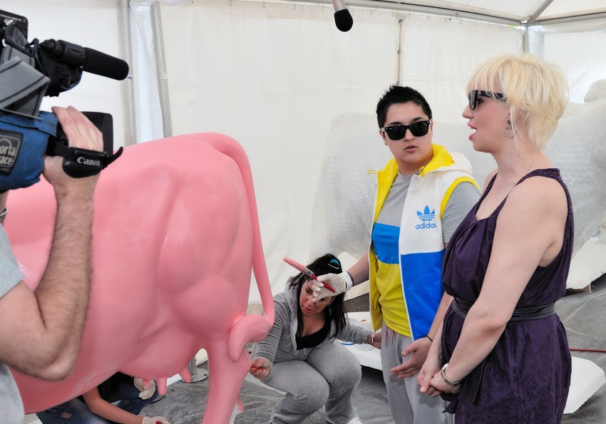 Marija Šerifović i Luna Lu na zadatku sa četkicom Organizator akcije je kompanija “Imlek“, a slični projakti do sada su održali u svetskim metropolama poput Londona, Njujorka, Pariza i Hong Konga više 75 drugih gradova u 30 država na šest kontinenata. - Mislim da je moja krava najoriginalnija i najmaštovitija. Zaposlio sam desetoro dece, uglavnom devojčica jer su one kreativnije, da je ofarbaju. Malo su farbale četkicima, malo rukama i napravile pravo remek delo. Mislim da je najrealnije da ova figura završi u nekoj dečjoj ustanovi - kaže uvek šaljivi Blaža.   Blaža sa mališanima Figure će narednih dana, između ostalih, oslikavati i glumac Branislav Lečić, nekadašnji odbojkaš Vanja Gbrić, pevač Danijel Pavlović, slikarka Biljana Cincarević, dizajner Slavimir Stojanović, deca iz Zvečanske, hor “Čarolija”, ekipa emisije “Top Model”, MTV, a “svoje“ krave već su ofarbače voditeljka Suzana Zlatanović, poznata kao Luna Lu, i pevačica Marija Šerifović.   Laza Ristovski farba svoje delo - Rado sam pristala da učestvujem pošto je ovo humanitarna akcija i bilo je veoma intersantno. Inače nisam baš vešta sa četkicom, ali tu je bilo i nekoliko umetnica koje su mi pomogle pa je bilo lakše - kaže Marija Šerifović, nekadašanja pobednica “Evrovizije“