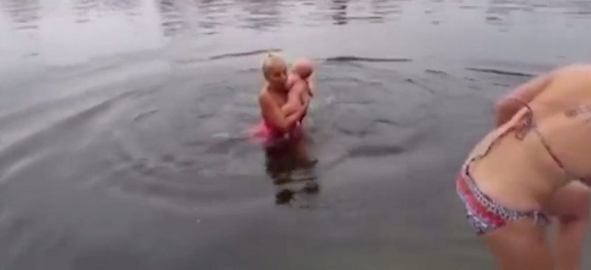 Szokujące wideo! W lodowatej wodzie kąpie niemowlaka