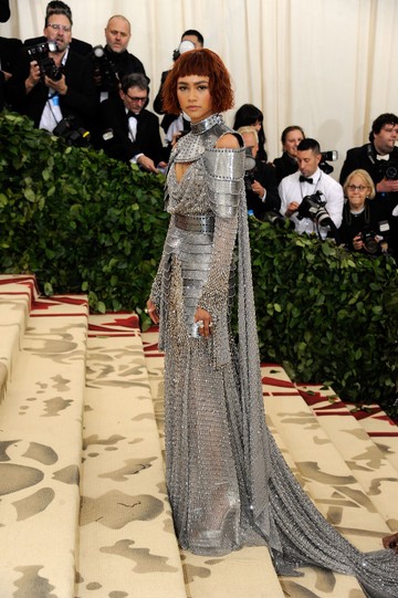 2018 Zendaya - A színésznő egy Jeanne d’Arc ihlette, páncélszerű ruhát viselt, amelyet a Versace divatházban álmodtak meg. A futurisztikus és erőteljes megjelenés tökéletesen illeszkedett az esemény „Heavenly Bodies” tematikájához.