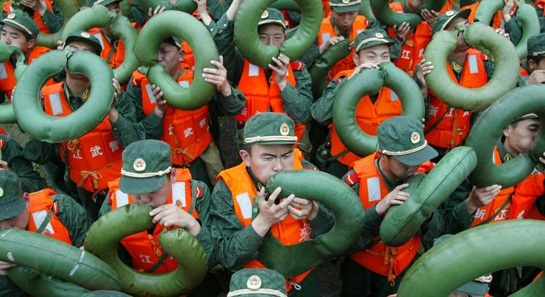 Paramilitary policemen blow up life buoys during a drill in preparation for the coming of typhoon Chanchu in east China's Zhejiang province May 17, 2006. Typhoon Chanchu, the strongest typhoon on record to enter the South China Sea in May and packing heavy rain and winds up to 170 kph (106 mph), made landfall between the cities of Shantou and Xiamen and was heading northeast, China Daily reported.