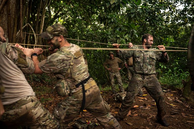 Air Force pararescuemen set up a rope system to cross a waterway in the jungle of Wahiawa, April 1, 2022.