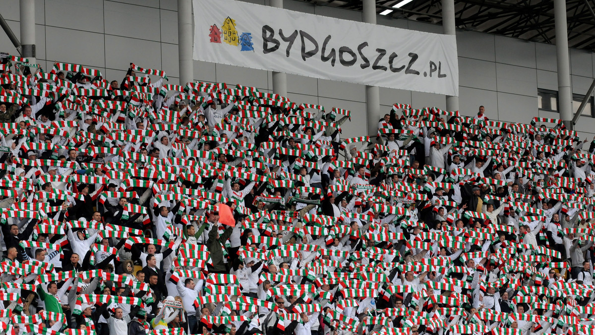 Oglądanie piłkarskiego meczu w telewizji, to niejako lizanie cukierka przez szybę. Nawet jak piękne byłoby widowisko, jak cudowne padały gole, jak świetnie spisywali się bramkarze, a sędziowie nie mylili się ani razu, to futbol przed ekranem jest erzacem prawdziwych emocji. Dopiero na stadionie czujemy dreszczyk, który jest nie do opanowania, gdy rykną kibice. Co śpiewają fani drużyn z Ekstraklasy? Najwyższy czas na to, by śpiewać każdy mógł… Poniżej prezentujemy swoisty śpiewnik ligowego kibica.