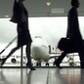 People walking through airport, silhouette (focus on aeroplane)