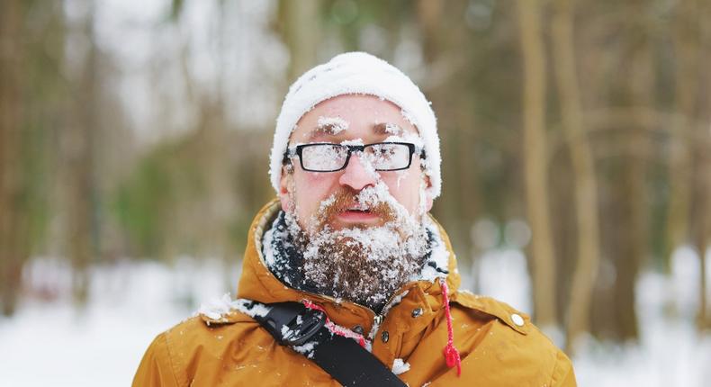 Happy man covered by snow enjoying winter